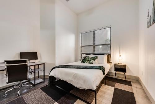 Un dormitorio con una cama, un escritorio y un televisor. en Stylish 2 Bedroom Apartment in Medical District, en Dallas