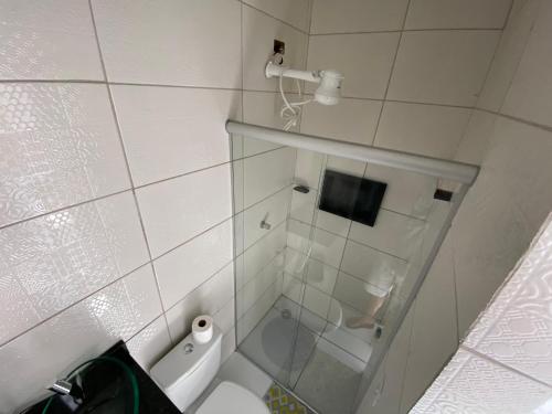 a small bathroom with a toilet and a shower at Ytamãní ll apartamentos in Santa Cruz Cabrália