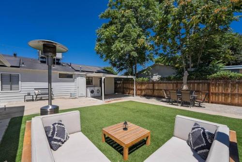 a backyard with a table and chairs and a wooden table at Magic Mountain 4 Bedroom 3 Bath Escape Modern Home in Santa Clarita