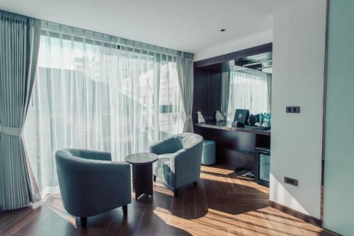 a living room with two chairs and a large window at Riverside Hotel in Vientiane