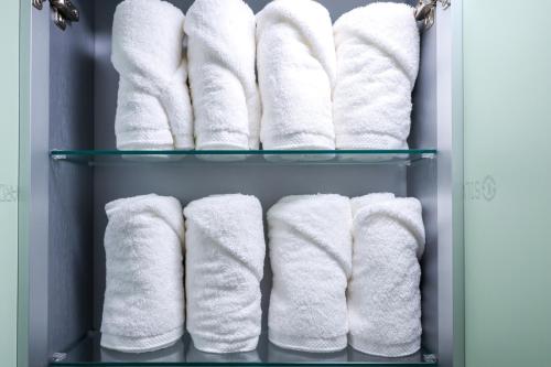 um cabide de toalhas brancas numa casa de banho em A Four Leaf Clover House em Namyangju