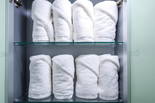 un estante de toallas blancas en el baño en A Four Leaf Clover House, en Namyangju
