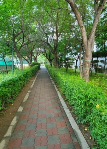 un camino de ladrillo en un parque con árboles en A Four Leaf Clover House, en Namyangju