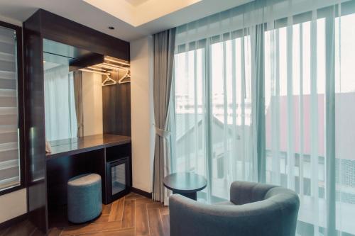 a living room with a chair and a window at Riverside Hotel in Vientiane