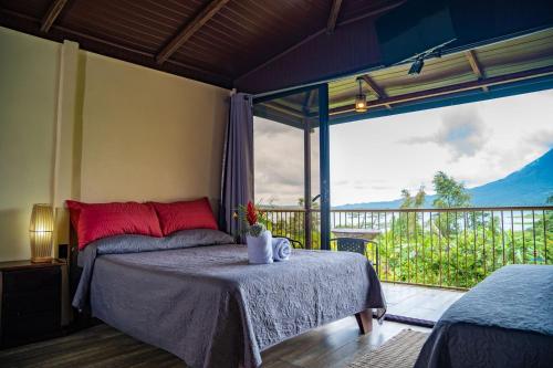 een slaapkamer met een bed en een groot raam bij Villas Paradise in El Castillo de La Fortuna