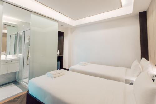 um quarto branco com uma cama e um espelho em Riverside Hotel em Vientiane
