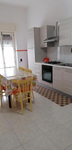 a kitchen with a table and chairs and a kitchen with a stove at Il sole in Maruggio