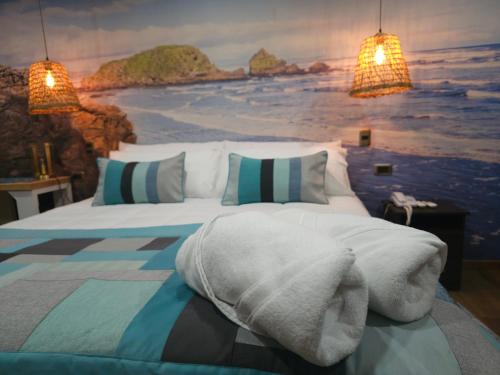 a bedroom with a bed with a painting on the wall at HOTEL BOUTIQUE TIERRA DE ISLAS Chiloé in Castro