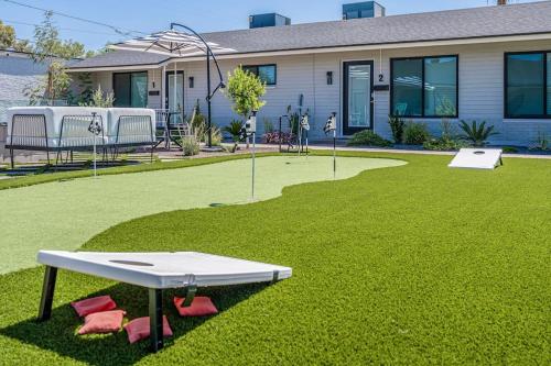- une table de ping-pong blanche sur une pelouse en face d'une maison dans l'établissement ASH and KO, à Phoenix