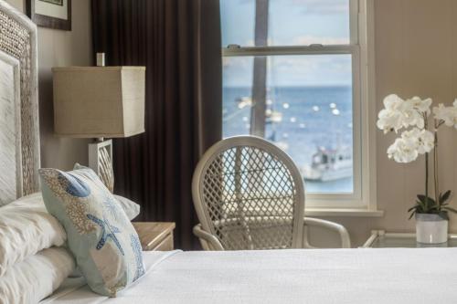a bedroom with a bed with a view of the ocean at Hotel Mac Rae in Avalon