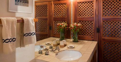 Un baño con un lavabo y un jarrón de flores. en CASA LAGO - LA PEÑA, en Valle de Bravo