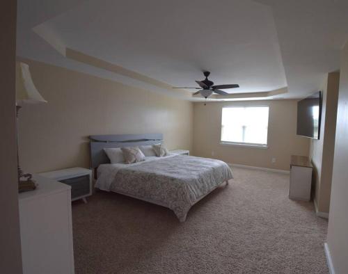 a bedroom with a bed and a ceiling fan at Peytons Ridge - entire house near Camp Lejeune and beaches in Hubert