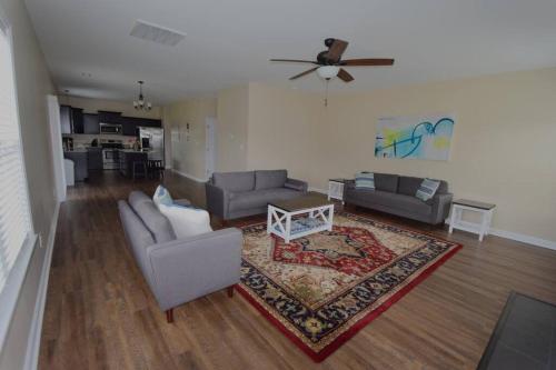 a living room with two couches and a ceiling fan at Peytons Ridge - entire house near Camp Lejeune and beaches in Hubert