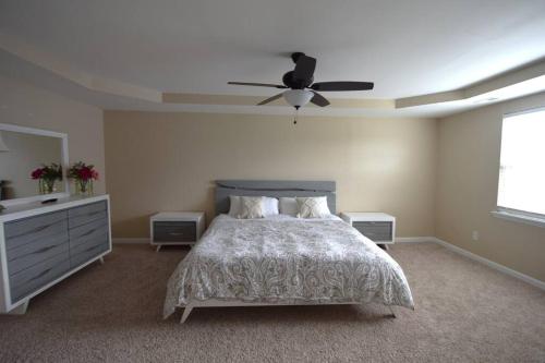 a bedroom with a bed and a ceiling fan at Peytons Ridge - entire house near Camp Lejeune and beaches in Hubert