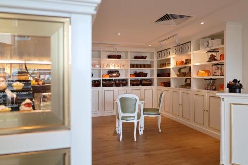 a kitchen with white cabinets and two chairs at Damai Lagoon Resort in Santubong