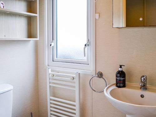 La salle de bains est pourvue d'un lavabo et d'une fenêtre. dans l'établissement Merse Place 4 - Uk45159, à Mainsriddle