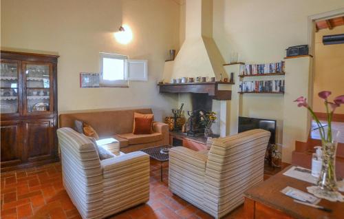 Una sala de estar con dos sillas y una chimenea. en Lovely Home In Castiglion Fiorentino, en Castiglion Fiorentino
