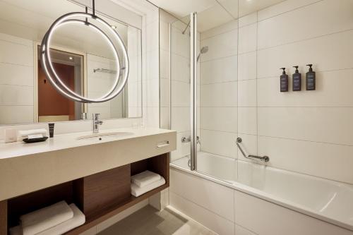 a bathroom with a sink and a shower and a mirror at Sheraton Frankfurt Airport Hotel & Conference Center in Frankfurt/Main