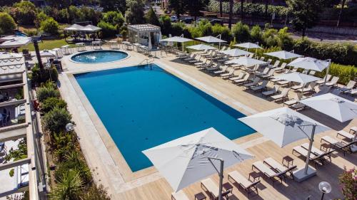 uma vista superior para uma piscina com cadeiras e guarda-sóis em Holiday Inn Rome - Eur Parco Dei Medici, an IHG Hotel em Roma
