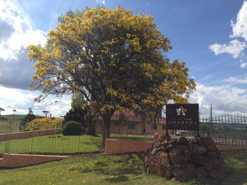Pousada Villa dos Vinhedos في ساو جواكيم: علامة أمام شجرة مع أوراق صفراء