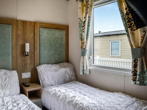 a small bedroom with a bed and a window at Sea View 14 - Uk45161 in Mainsriddle