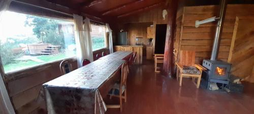 een kamer met een houtkachel in een blokhut bij cabaña el descanso in Lago Ranco