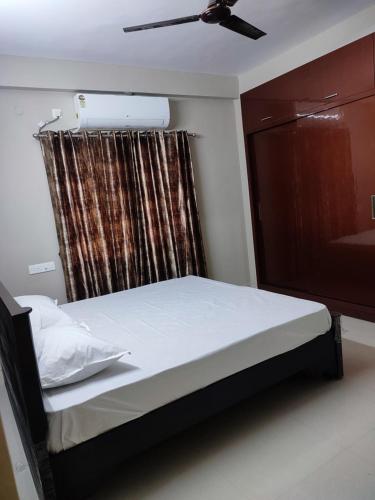 a bedroom with a bed with a ceiling fan and a window at Rahul guest house in Visakhapatnam