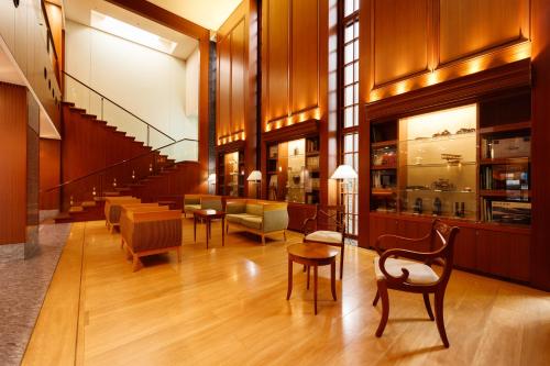 a lobby with chairs and tables in a building at Kanazawa New Grand Hotel Premier in Kanazawa