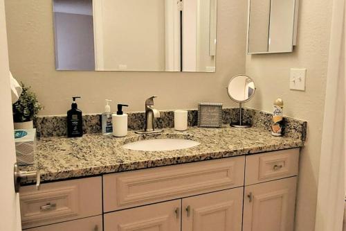 a bathroom counter with a sink and a mirror at 2bd/2bth Modern Condo on International Dr. w Pool ! Near Sea World and Universal in Orlando