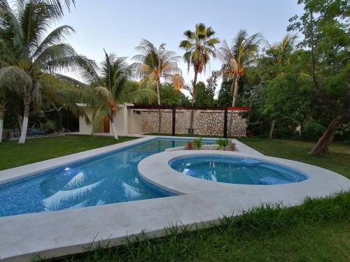 a swimming pool in a yard with palm trees at Marysol d10 private beach next to nomads in Isla Mujeres