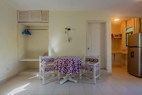 a kitchen with a table and chairs and a refrigerator at Marysol d10 private beach next to nomads in Isla Mujeres