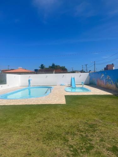 2 piscinas en un patio con una pared en Aconchego em Maragogi, en Maragogi