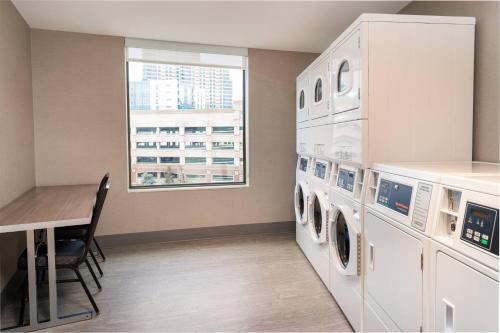 a laundry room with washing machines and a table at Residence Inn by Marriott Grand Rapids Downtown in Grand Rapids