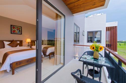 a bedroom with a bed and a balcony at Sun Paradise Villa Hoi An in Hoi An