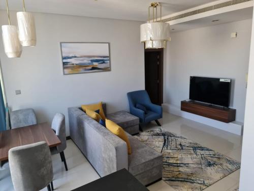 شقة مفروشة جديدة مؤثثة بالكامل بالجفير في المنامة: غرفة معيشة مع أريكة وتلفزيون