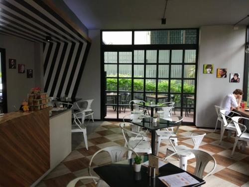 a restaurant with tables and chairs and a window at iSanook Bangkok in Bangkok