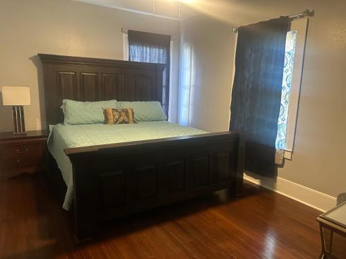 a bedroom with a bed with a wooden headboard at Cozy Louisiana Living Highland Historic District in Shreveport