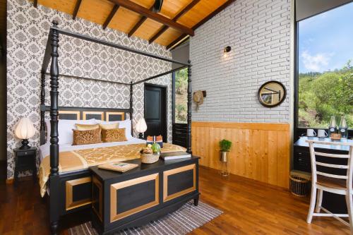 a bedroom with a bed and a desk and a table at The Capoe House in Haputale