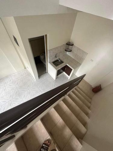 uma vista superior de uma escada com um lavatório e uma cozinha em Aien's Apartelle em Mati