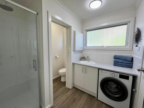 a bathroom with a washing machine and a sink at Gowings of Mallacoota in Mallacoota