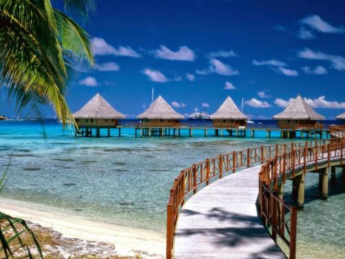 a bridge over the ocean with overwater bungalows at Dragon hotel in Ha Long