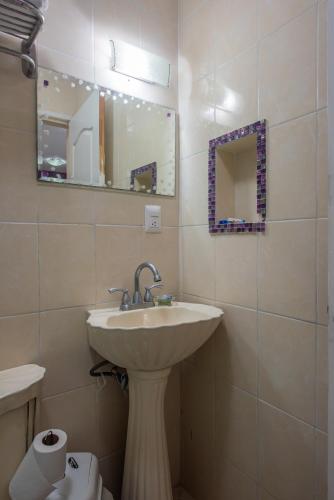 a bathroom with a sink and a mirror and a toilet at Marysol d11 private beach next to nomads in Isla Mujeres