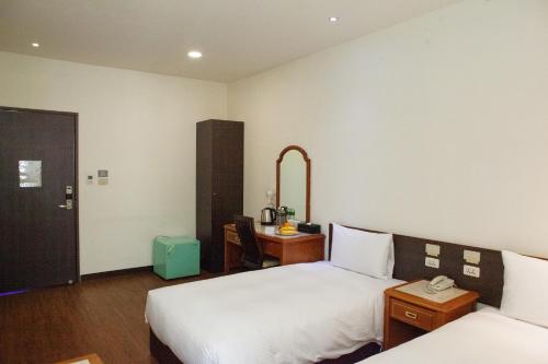a hotel room with two beds and a desk at YUAI FU HAO Hotel in Taichung