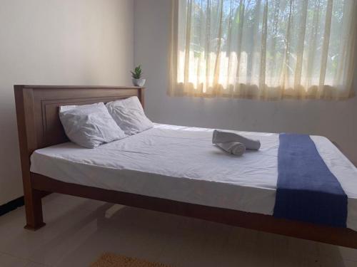 - un lit dans une chambre dotée d'une fenêtre et d'un oreiller dans l'établissement CMSurf Guest, à Ahangama