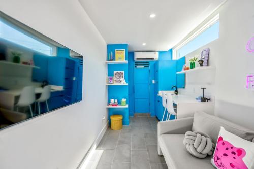 sala de estar con paredes azules y sofá en Blueberry Container @ EADO Juice Box, en Houston