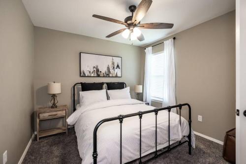 1 dormitorio con 1 cama y ventilador de techo en NEW! Beautiful and Spacious Home, en Ozark
