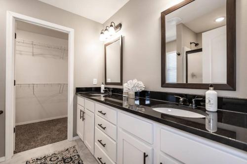 baño con lavabo y espejo grande en NEW! Beautiful and Spacious Home, en Ozark