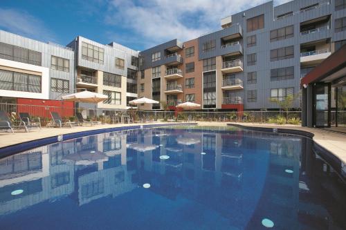 a large swimming pool in front of some buildings at Club Wyndham Lakes Entrance in Lakes Entrance