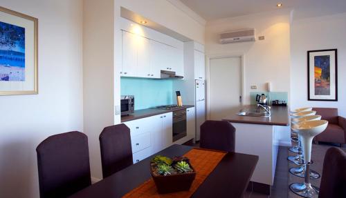 a kitchen and dining room with a table and chairs at Club Wyndham Lakes Entrance in Lakes Entrance