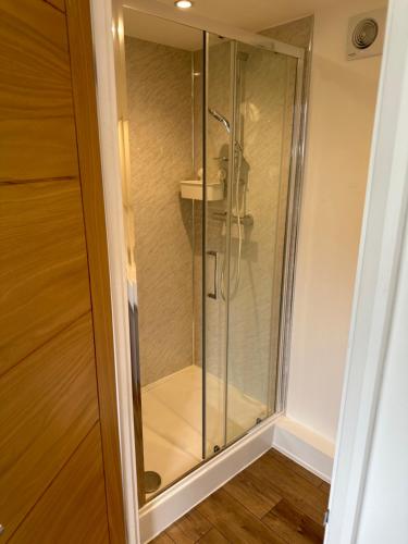 een glazen douche in een badkamer met een wastafel bij Glastonbury Vista in Glastonbury